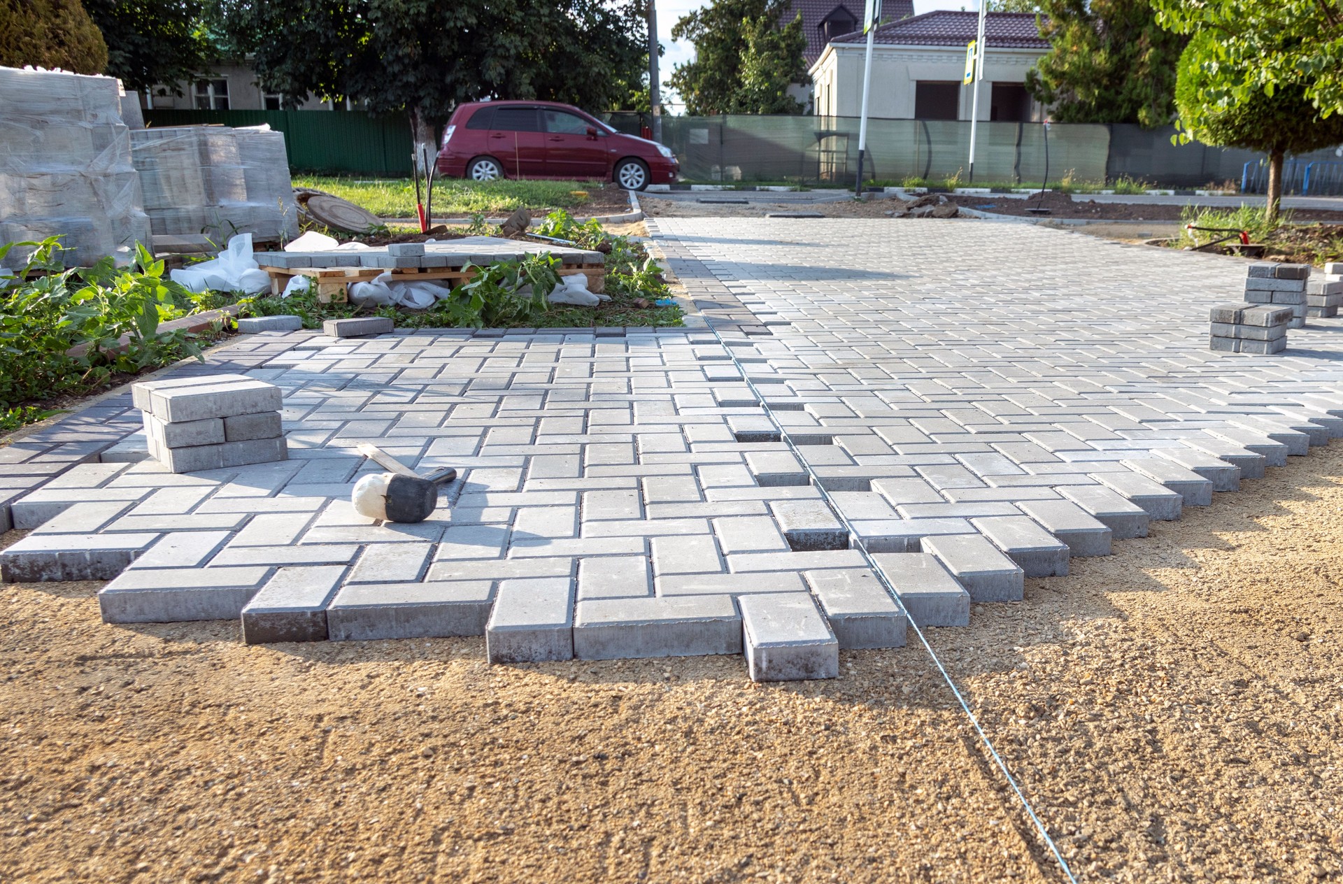 A worker lays paving slabs. Laying tiles in the garden of the city park.